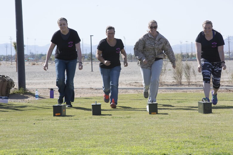 Marine Wing Support Squadron 374 spouses and family members rush to pick up ammo cans during the physical training portion of the squadron’s Jane Wayne Dayat Del Valle field, April 29, 2016. (Official Marine Corps photo by Cpl. Julio McGraw/Released)