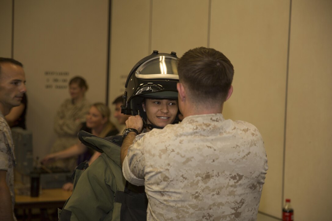 Gabriella Martin, wife of Lance Cpl. Jacob Martin, aircraft rescue and firefighting specialist, Marine Wing Support Squadron 374, tries on the bomb disposal suit, during the squadrons Jane Wayne Day, at Bldg. 1707 April 29, 2016. (Official Marine Corps photo by Cpl. Julio McGraw/Released)
