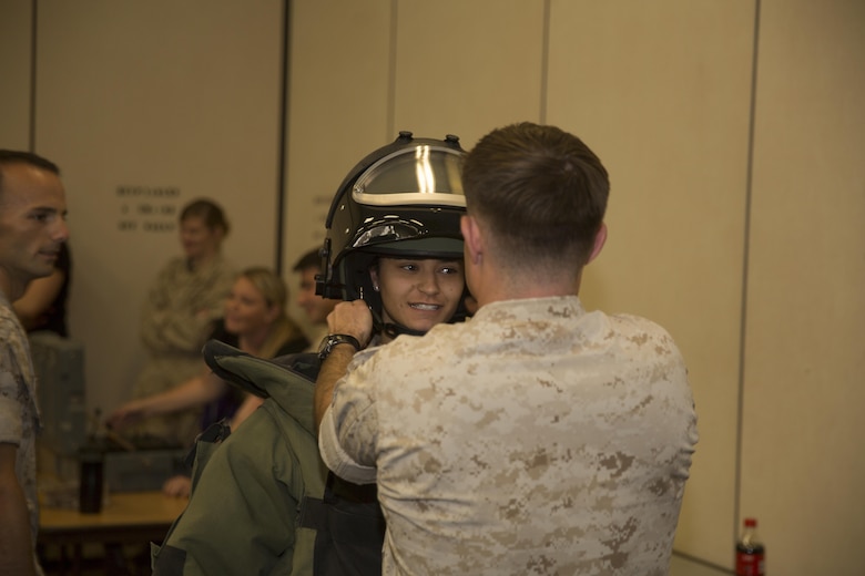 Gabriella Martin, wife of Lance Cpl. Jacob Martin, aircraft rescue and firefighting specialist, Marine Wing Support Squadron 374, tries on the bomb disposal suit, during the squadrons Jane Wayne Day, at Bldg. 1707 April 29, 2016. (Official Marine Corps photo by Cpl. Julio McGraw/Released)