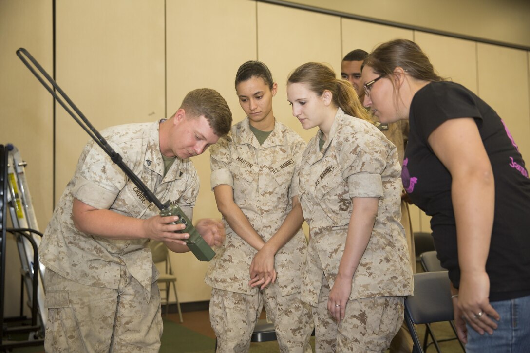 Cpl. Jordan Crouse, field radio operator, Marine Wing Support Squadron 374, shows spouses a AN/PRC-152 single-channel multiband, multimission hand-held radio at bldg. 1707 during the squadron’s Jane Wayne Day April 29, 2016. (Official Marine Corps photo by Cpl. Julio McGraw/Released)
