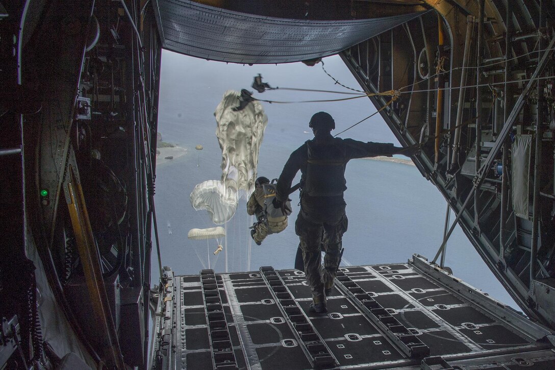 Sailors perform a static line jump from a C-130 Hercules off the coast of Guam during exercise Tricrab, May 18, 2016. The sailors are assigned to Explosive Ordnance Disposal Mobile Unit 5. Tricrab focuses on strengthening relationships within the Asia-Pacific region through training and information exchanges to enhance explosive ordnance disposal and diving-related interoperability. Navy photo by Petty Officer 1st Class Doug Harvey