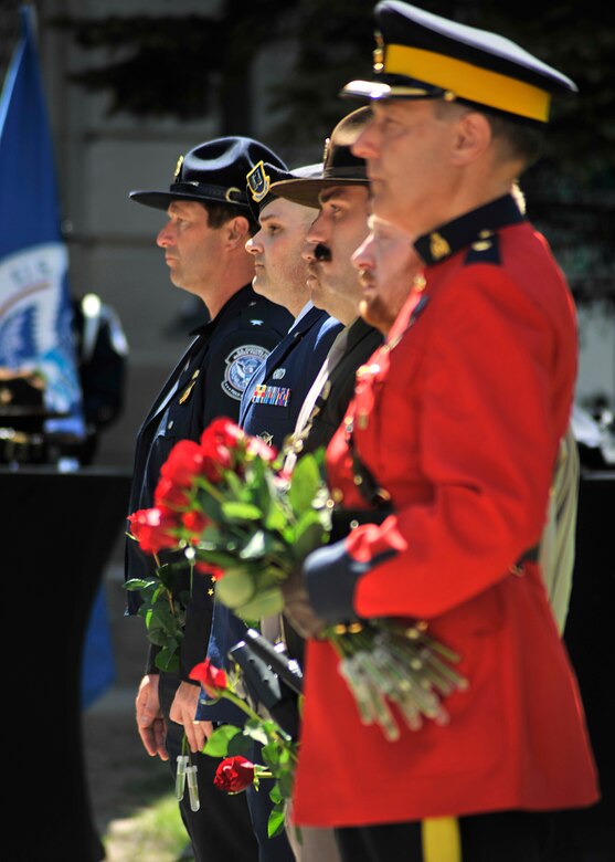 Members of law enforcement stand at attention waiting to honor his fellow fallen warriors during the National Police Week Memorial Service at Grand Forks County Court House May 17, 2016, in Grand Forks, N.D. The memorial service was to honor 35 local police officers who sacrificed their lives within their line of duty. (U.S. Air Force photo/Senior Airman Xavier Navarro)