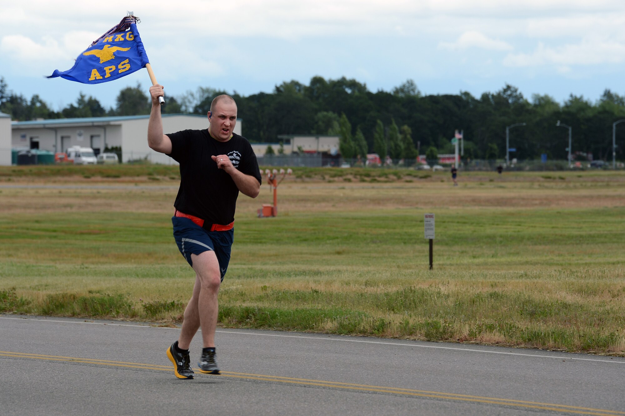 1st Lt. Peter Williams, 62nd Aerial Port Squadron passenger terminal officer in charge, runs with the squadron’s guidon during this year’s 62nd APS 5K Memorial Run May 18, 2016, on Joint Base Lewis-McChord, Wash. Unifying the aerial port community, the run was open to active duty, Guard and Reserve Airmen and their families from McChord Field. (U.S. Air Force photo/Senior Airman Jacob Jimenez) 