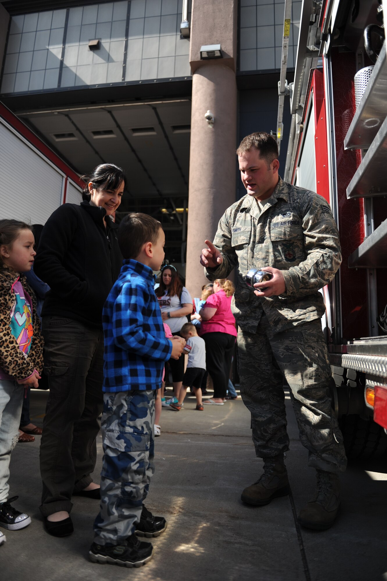 Senior Airman Christopher Smith, 5th Civil Engineer Squadron, talks with children from the Minot Air Force Base Pre school Co-op at the Minot AFB fire department on Minot AFB, N.D. May 16, 2016. The Co-op is a group of parents that meet together weekly to teach their kids various school subjects and visited the fire department which was part of several last day events before taking a summer hiatus. (U.S. Air Force photo by Staff Sgt. Chad Trujillo)