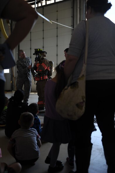 Staff Sgt. Taylor Gerdes and Airman 1st Class Brandon Burns, both 5th Civil Engineer Squadron, demonstrate some of their firefighter gear for the Minot Air Force Base Pre school Co-op at the fire department on Minot AFB, N.D. May 16, 2016. The Co-op is a group of parents that meet together weekly to teach their kids various school subjects and visited the fire department which was part of several last day events before taking a summer hiatus. (U.S. Air Force photo by Staff Sgt. Chad Trujillo)
