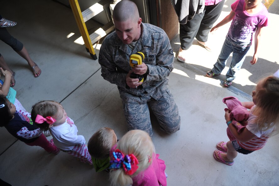 Staff Sgt. Taylor Gerdes, 5th Civil Engineer Squadron, talks with children from the Minot Air Force Base Pre school Co-op at the Minot AFB fire department on Minot AFB, N.D. May 16, 2016. The Co-op is a group of parents that meet together weekly to teach their kids various school subjects and visited the fire department which was part of several last day events before taking a summer hiatus. (U.S. Air Force photo by Staff Sgt. Chad Trujillo)