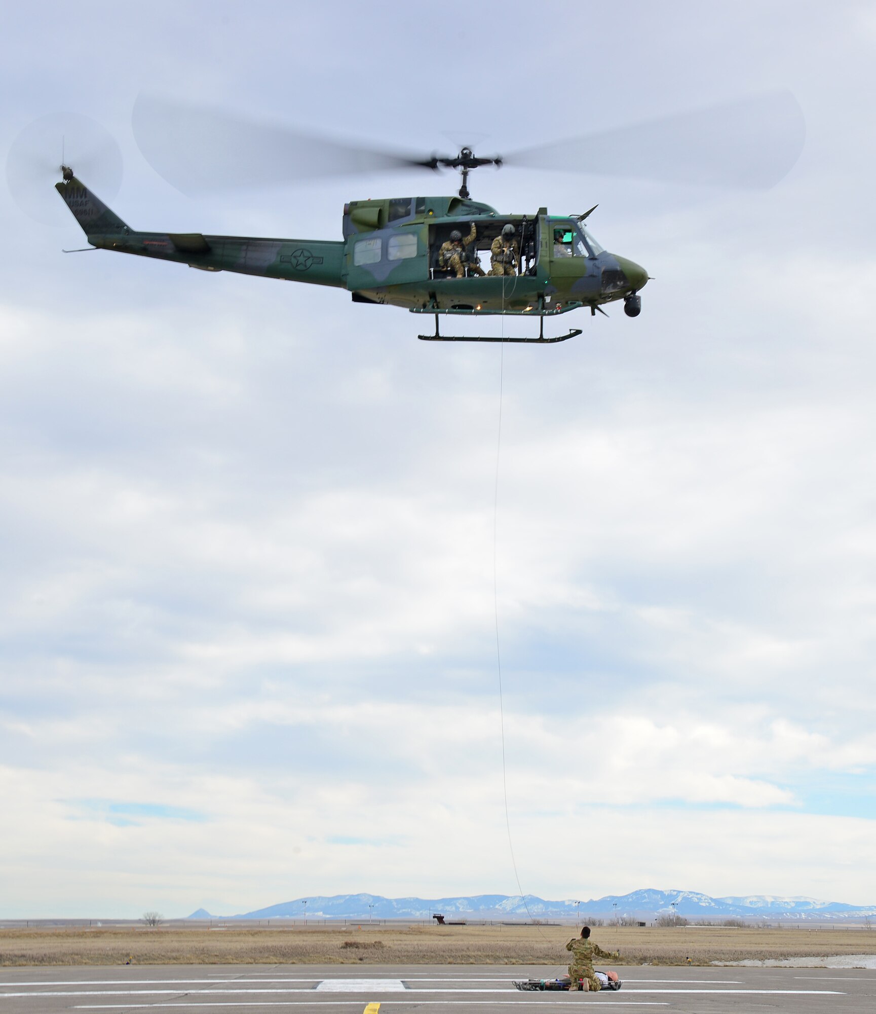 Members of the 40th Helicopter Squadron train using a Stokes litter to raise a simulated injured patient into the aircraft Feb. 2, 2016, at Malmstrom Air Force Base, Mont. A UH-1N Huey helicopter crew assigned to the 40th HS recorded the unit’s 414th save after rescuing an injured driver near Livingston, Montana, May 13. (U.S. Air Force photo/Airman Daniel Brosam)
