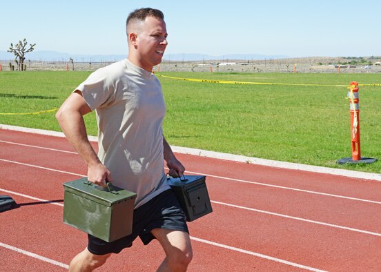 Senior Airman Nicholas Covello, 412th Security Forces Squadron, carries full ammunition cans during a race against fellow defenders May 19 at the base gym. Several events were held between teams for the Defender Olympics, a morale-boosting event held during National Police Week. (U.S. Air Force photo by Kenji Thuloweit) 