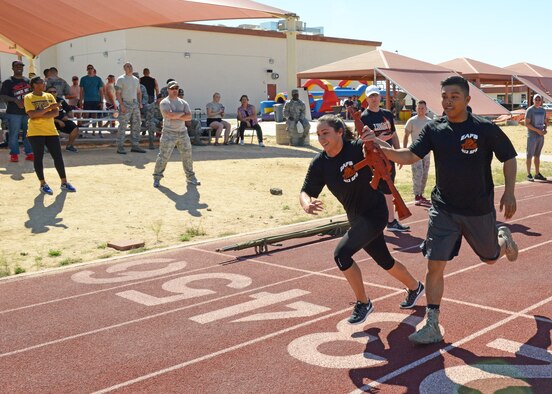 Staff Sgt. Nastasha Guerrero, 412th Security Forces Squadron, takes off running after receiving a dummy rifle from fellow defender Senior Airman Renz Dela Cruz during a relay race at the Defender Olympics May 19. (U.S. Air Force photo by Kenji Thuloweit) 