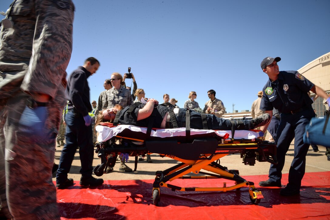 Emergency responders from agencies surrounding Hill Air Force Base move a simulated victim during a mass casualty exercise May 18 at the base. The exercise revolved around a terrorist incident resulting in a mass casualty scenario. Approximately 200 students from the Clearfield (Utah) Job Corps and nearly 30 emergency response agencies, including local hospitals, fire departments, law enforcement and emergency operation centers participated. (U.S. Air Force photo by R. Nial Bradshaw)