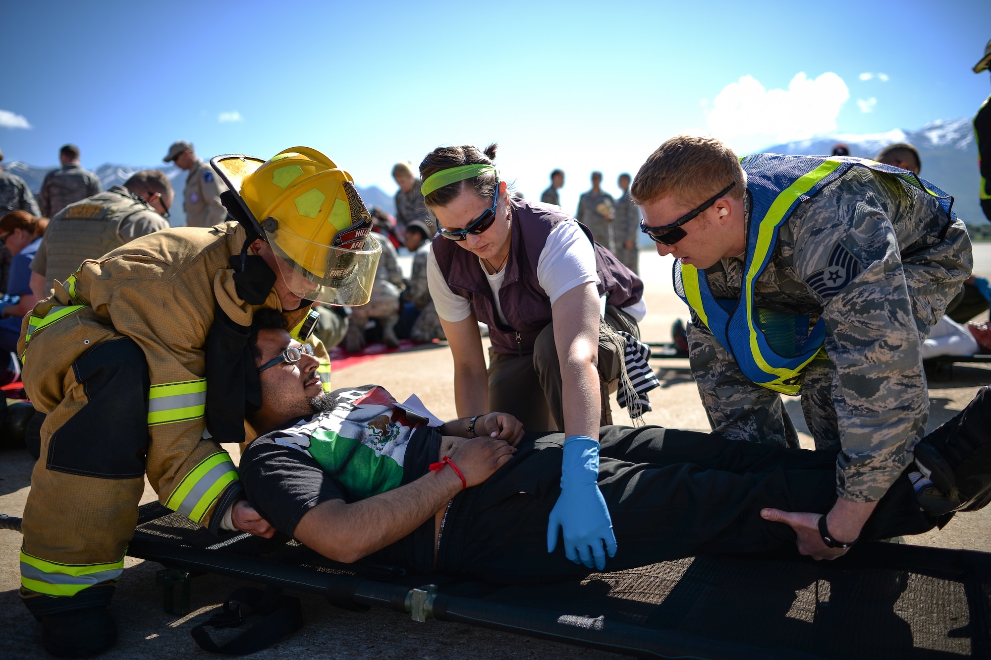 Emergency responders from Hill Air Force Base and local agencies lift a simulated victim onto a stretcher during a mass casualty exercise May 18 at the base. Emergency response activities were exercised on the Hill AFB flight line and involved nearly 30 emergency response agencies, including local hospitals, fire departments, law enforcement and emergency operation centers. (U.S. Air Force photo by R. Nial Bradshaw)