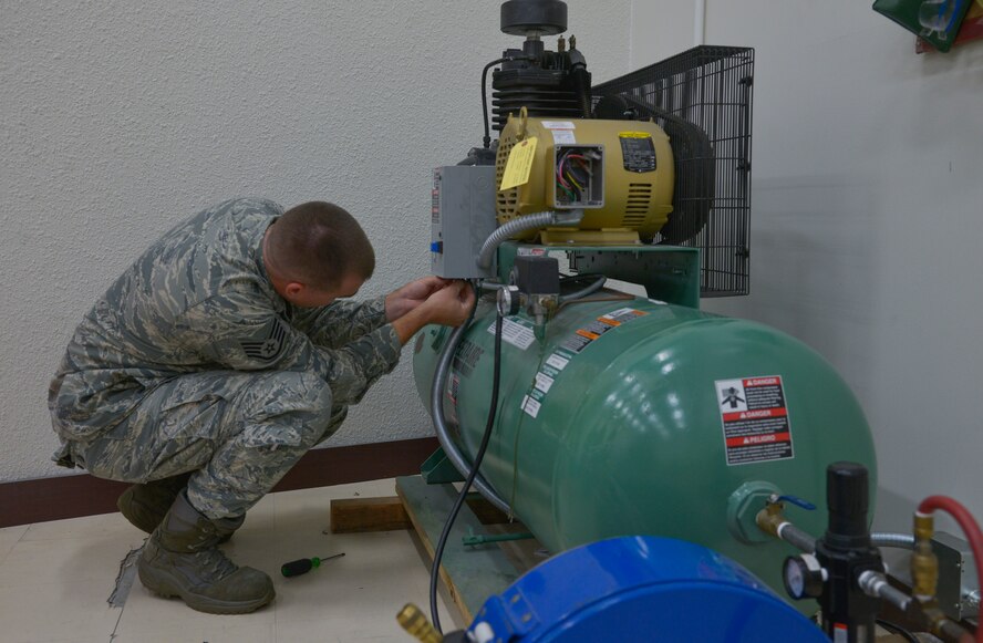 Staff Sgt. Corey Trowbridge, 932nd Civil Engineer Squadron electrical systems technician, from Scott Air Force Base, Illinois, tightens a bolt on a distribution box at Yokota Air Base, Japan, May 17, 2016. The motor and new air compressor allows the aircrew flight equipment personnel to inflate and inspect life rafts eight times faster than before. (U.S. Air Force photo by Senior Airman David Owsianka/Released)