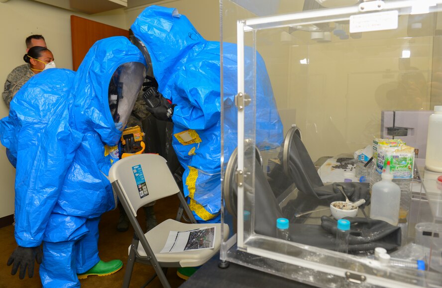 Members of the 374th Aerospace Medical Squadron and 374th Civil Engineer Squadron communicate to assess a simulated chemical threat at Yokota Air Base, Japan, May 13, 2016. They were tested on their ability to locate and identify simulated hazardous materials in a mock terrorist compound. (U.S. Air Force photo by Airman 1st Class Elizabeth Baker/Released)