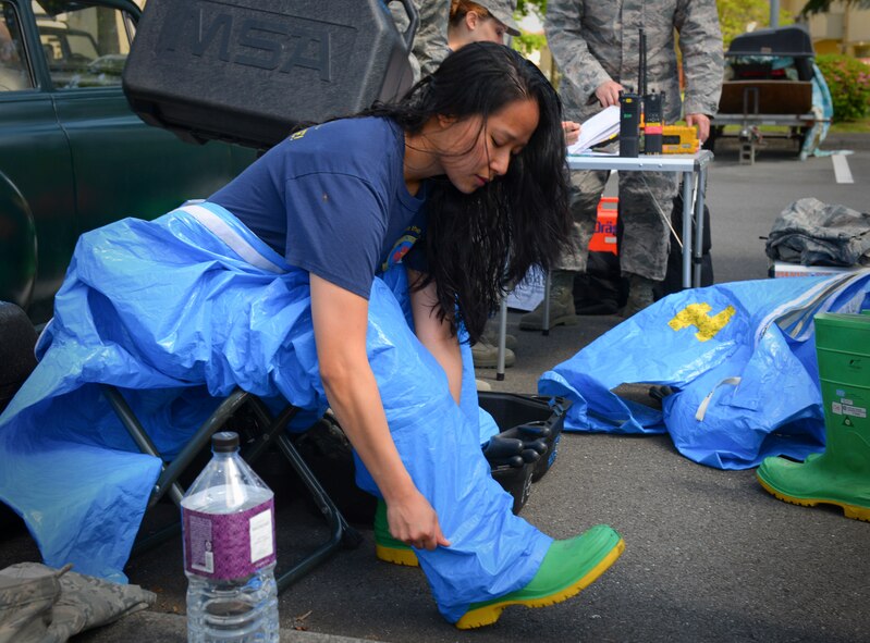 Staff Sgt. Karina Sendayen, 374th Aerospace Medical Squadron NCO in charge of readiness, dons chemical protection gear during an exercise at Yokota Air Base, Japan, May 13, 2016. Personnel were tested on their ability to assess a simulated chemical threat under various pressures such as a managing oxygen supply, time constraints and the physical challenges of wearing chemical protection gear. (U.S. Air Force photo by Airman 1st Class Elizabeth Baker/Released)