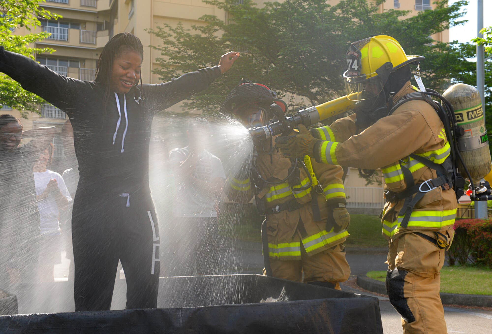 Fire fighters with the 374th Civil Engineer Squadron simulate hazardous material decontamination on role players at Yokota Air Base, Japan, May 13, 2016. The 374 CES tested their response to simulated chemical attacks in a realistic setting. (U.S. Air Force photo by Airman 1st Class Elizabeth Baker/Released)