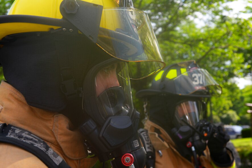 Airman 1st Class Brendan Ryan, 374th Civil Engineer Squadron fire fighter and Yasuo Kimura, 374 CES fire truck operator, prepare to respond to simulated chemical attack victims at Yokota Air Base, Japan, May 13, 2016. The 374 CES tested their response to simulated chemical attack in a realistic setting. (U.S. Air Force photo by Airman 1st Class Elizabeth Baker/Released)