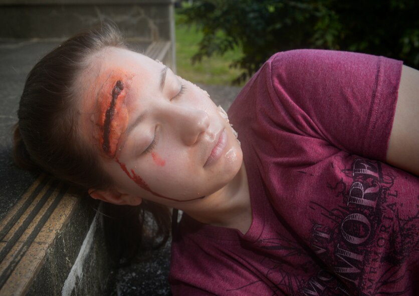 Airman 1st Class Amber Mutton, 374th Aerospace Medical Squadron surgical technician, roleplays as a chemical burn and head trauma victim at Yokota Air Base, Japan, May 13, 2016. Mutton and approximately 25 other volunteers roleplayed as victims during an exercise which tested Yokota’s ability to respond to an active shooter, chemical threats and mass victims. (U.S. Air Force photo by Airman 1st Class Elizabeth Baker/Released)