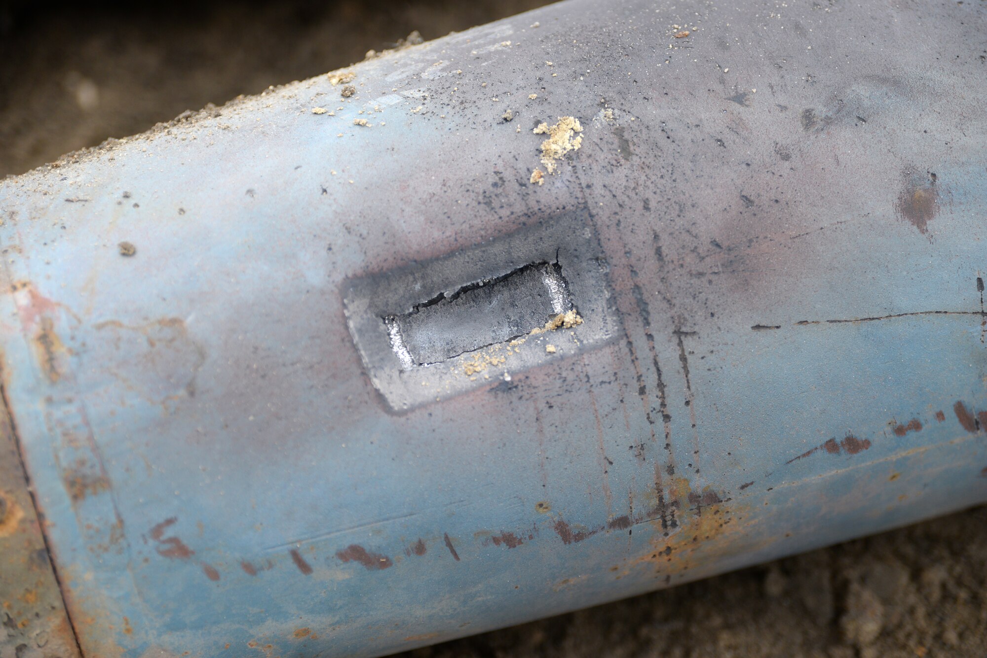 A picture of a close-up view of the rectangular deformation on a BDU-50 500 lb. concrete-filled practice bomb.