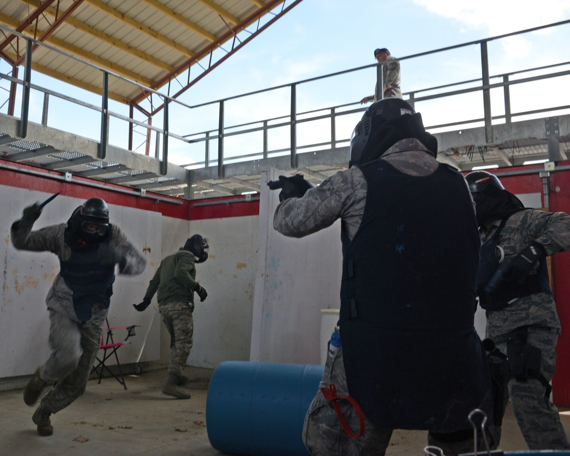 U.S. Air Force Staff Sgt. Michael P. Johnson, 157th Security Forces Squadron NCO in charge of Combat Arms, left, attempts to attack Airmen from the 157 SFS during a use of force training scenario at Sig Sauer Academy, Epping, N.H. May 14, 2016. The personal protective equipment they are wearing provides them protection from the non-lethal training ammunition tipped with colored dye which they are using. (U.S. Air National Guard photo by Airman 1st Class Ashlyn J. Correia)