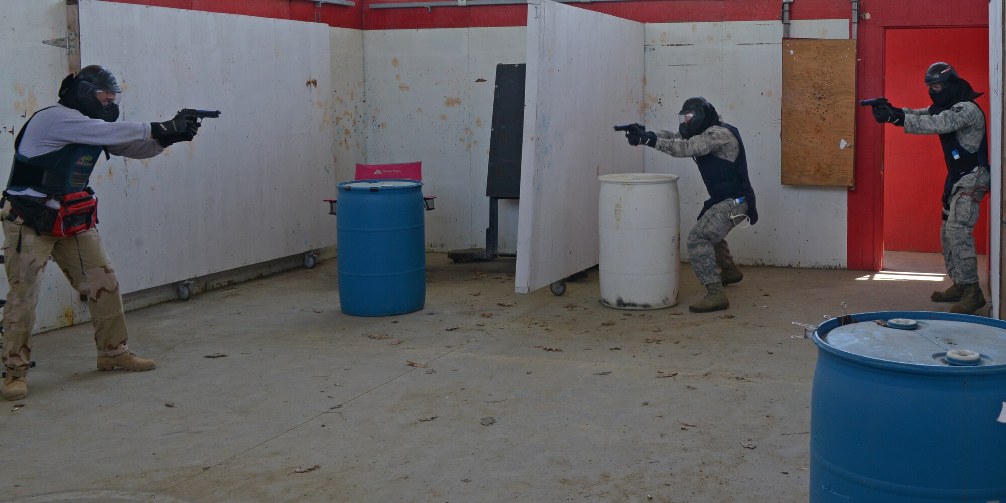 U.S. Air Force Tech. Sgt. Thomas J. Moore, 157th Security Forces Squadron flight chief, exchanges fire with other 157 SFS members during a use of force training scenario at Sig Sauer Academy, Epping, N.H. May 14, 2016. The personal protective equipment they are wearing provides them protection from the non-lethal training ammunition tipped with colored dye which they are using. (U.S. Air National Guard photo by Airman 1st Class Ashlyn J. Correia)