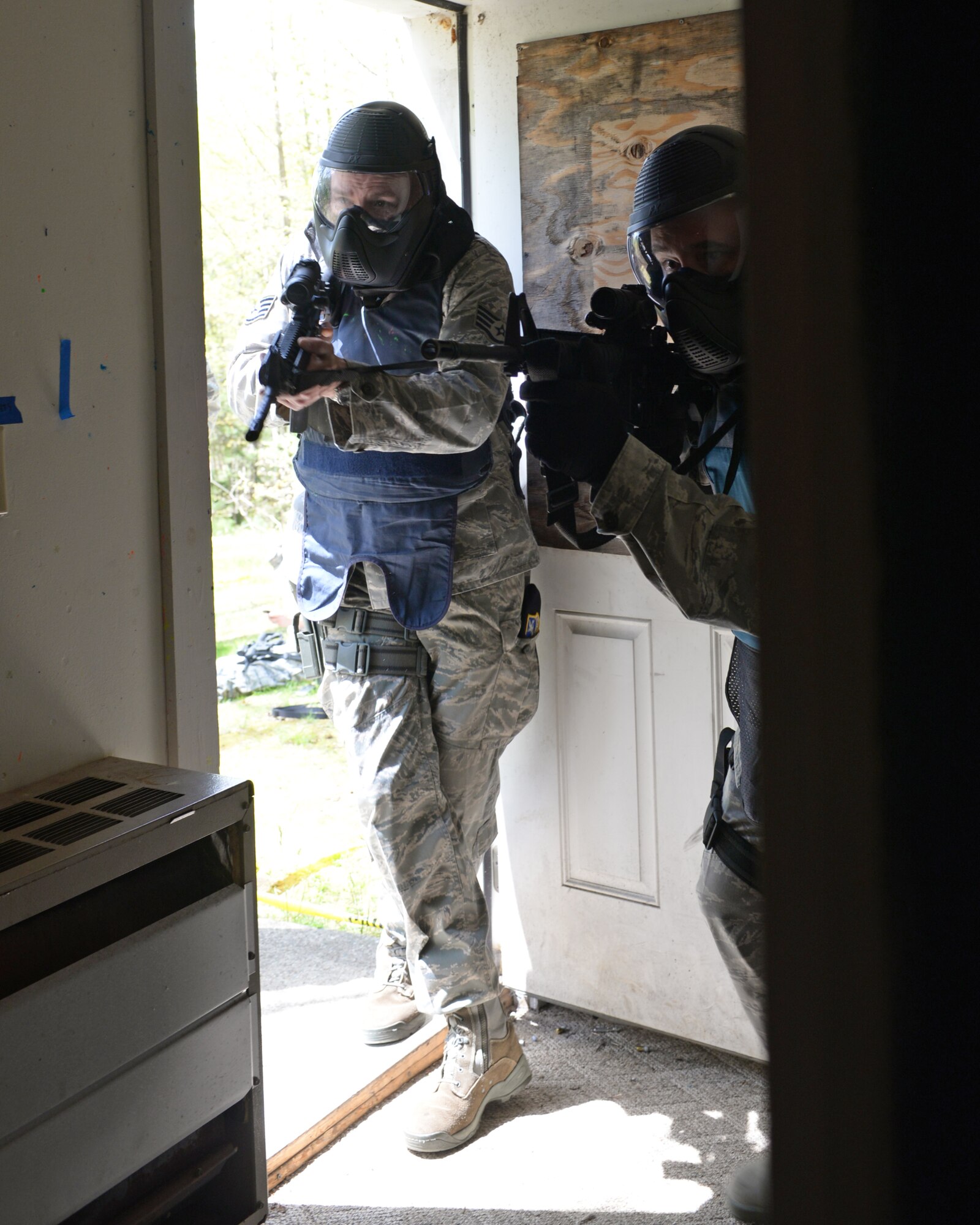 U.S. Air Force Staff Sgt. Michael P. Johnson, 157th Security Forces Squadron NCO in charge of Combat Arms, left, and Tech. Sgt. Philip J. Soares, 157 SFS craftsman move through a doorway during an active shooter training scenario at Sig Sauer Academy, Epping, N.H. May 14, 2016.  The personal protective equipment they are wearing provides them protection from the non-lethal training ammunition tipped with colored dye which they are using. (U.S. Air National Guard photo by Airman 1st Class Ashlyn J. Correia)