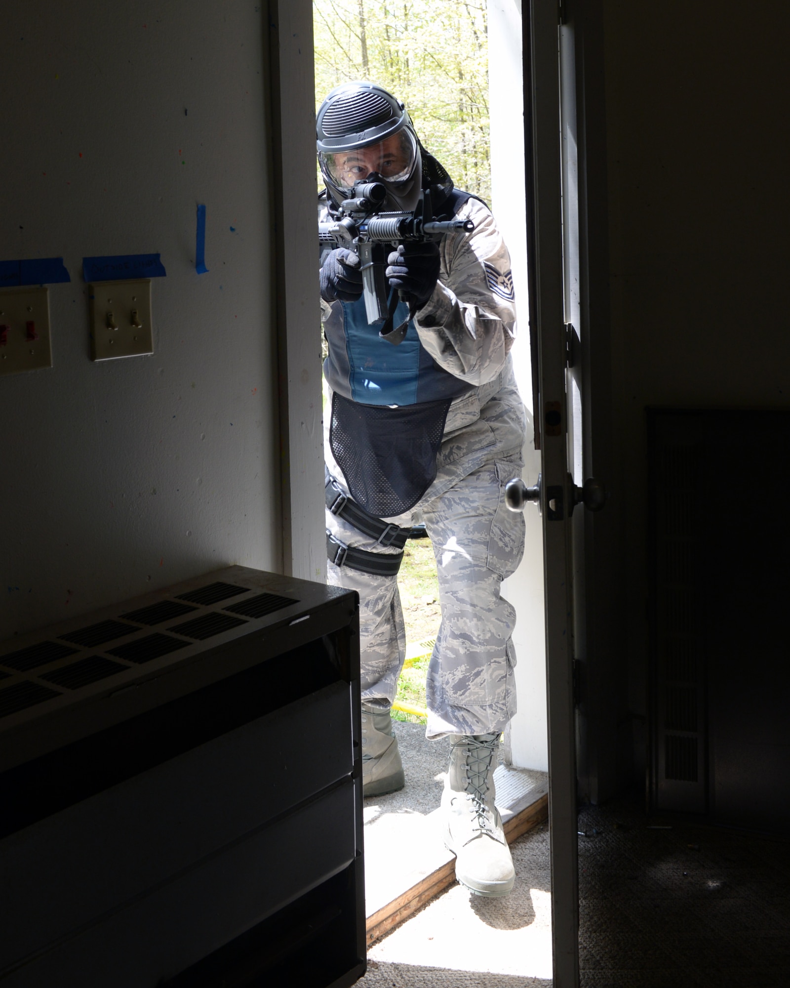 U.S. Air Force Tech. Sgt. Philip J. Soares, 157th Security Forces Squadron craftsman, moves through a doorway during an active shooter training scenario at Sig Sauer Academy, Epping, N.H. May 14, 2016.  The personal protective equipment he is wearing provides him protection from the non-lethal training ammunition tipped with colored dye which he is using. (U.S. Air National Guard photo by Airman 1st Class Ashlyn J. Correia) 