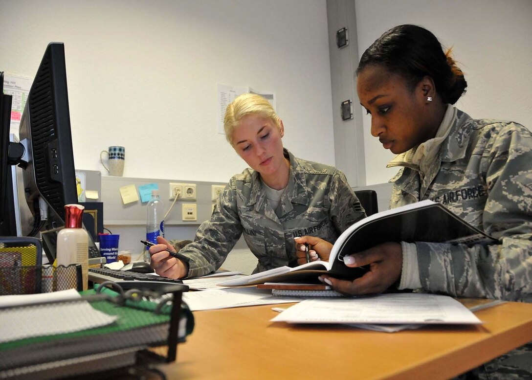 SPANGDAHLEM, Germany - Passenger travel clerk, Senior Airman Rakarah Bellini, from the 52nd Fighter Wing and traffic management specialist, Airman 1st Class Maimuna Marques, from the 104th Fighter Wing are busy at work issuing travel tickets to Service Members, May 17, 2016. Marques is one of approximately 100 Airmen from the 104th Fighter Wing, Barnes Air National Guard Base, Mass.,to deploy to Germany to train side-by-side with their active duty counterparts.  Integration training allows Service Members the opportunity to learn from each other and put that knowledge to use during a combat deployment. (U.S. Air National Guard photo by Senior Airman Loni Kingston/Released)