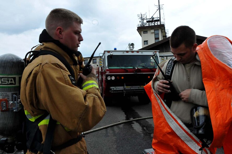 SPANGDAHLEM, Germany -  Tech. Sgt. Karl Reinholz, assists Staff Sgt. Ryan Hart don his HAZMAT gear during a duel-component training mission with their 52nd Fighter Wing, active duty counterparts, May 18, 2016. Reinholz and Hart are among nearly 100 Airmen from the 104th Fighter Wing deployed to Germany for annual training in an effort to support total force integration which combines reservists with active duty Service Members to create one seamless Air Force (U.S. Air National Guard photo by Senior Airman Loni Kingston/Released)