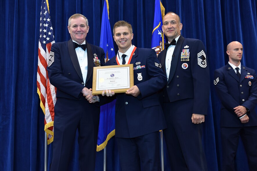 MCGHEE TYSON AIR NATIONAL GUARD BASE, Tenn. - Senior Airman Kirby Davis, center, takes his diploma here May 18, 2016, as a distinguished graduate of the Airman leadership school, class 16-5, during the graduation banquet at the Chief Master Sgt. Paul H. Lankford Enlisted Professional Military Education Center. (U.S. Air National Guard photo by Master Sgt. Mike R. Smith/Released)