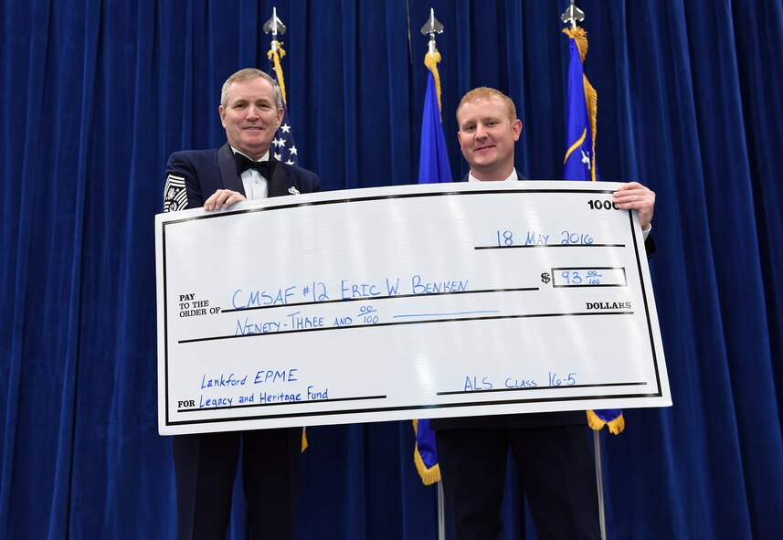 MCGHEE TYSON AIR NATIONAL GUARD BASE, Tenn. - 12th Chief Master Sgt. of the Air Force Eric W. Benken, retired, is presented here May 18, 2016, with a $93 donation in his name to the Lankford EPME Legacy and Heritage Fund by Staff Sgt. Jason Savary as a token of appreciation on behalf of the Airman leadership school class during their graduation banquet at the Chief Master Sgt. Paul H. Lankford Enlisted Professional Military Education Center. Benken was the banquet's featured speaker. (U.S. Air National Guard photo by Master Sgt. Mike R. Smith/Released)