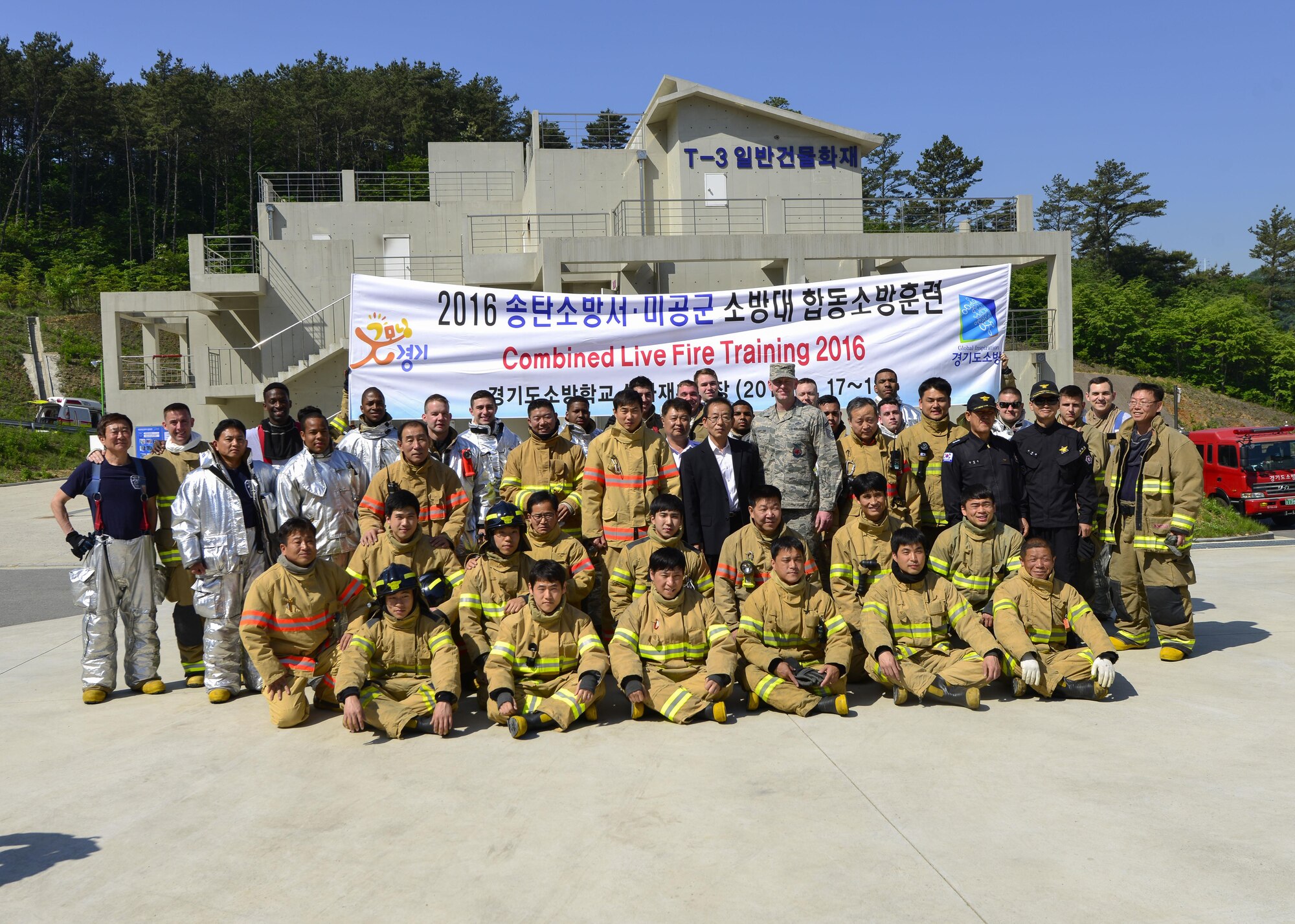 Firefighters from the 51st Civil Engineer Squadron fire and emergency services flight pose with members of the Songtan fire department at the Kyonggi-do Fire Academy, Republic of Korea, May 18, 2016. The firefighters prepared for a live fire training exercise at the fire academy. (U.S. Air Force photo by Senior Airman Victor J. Caputo/Released)