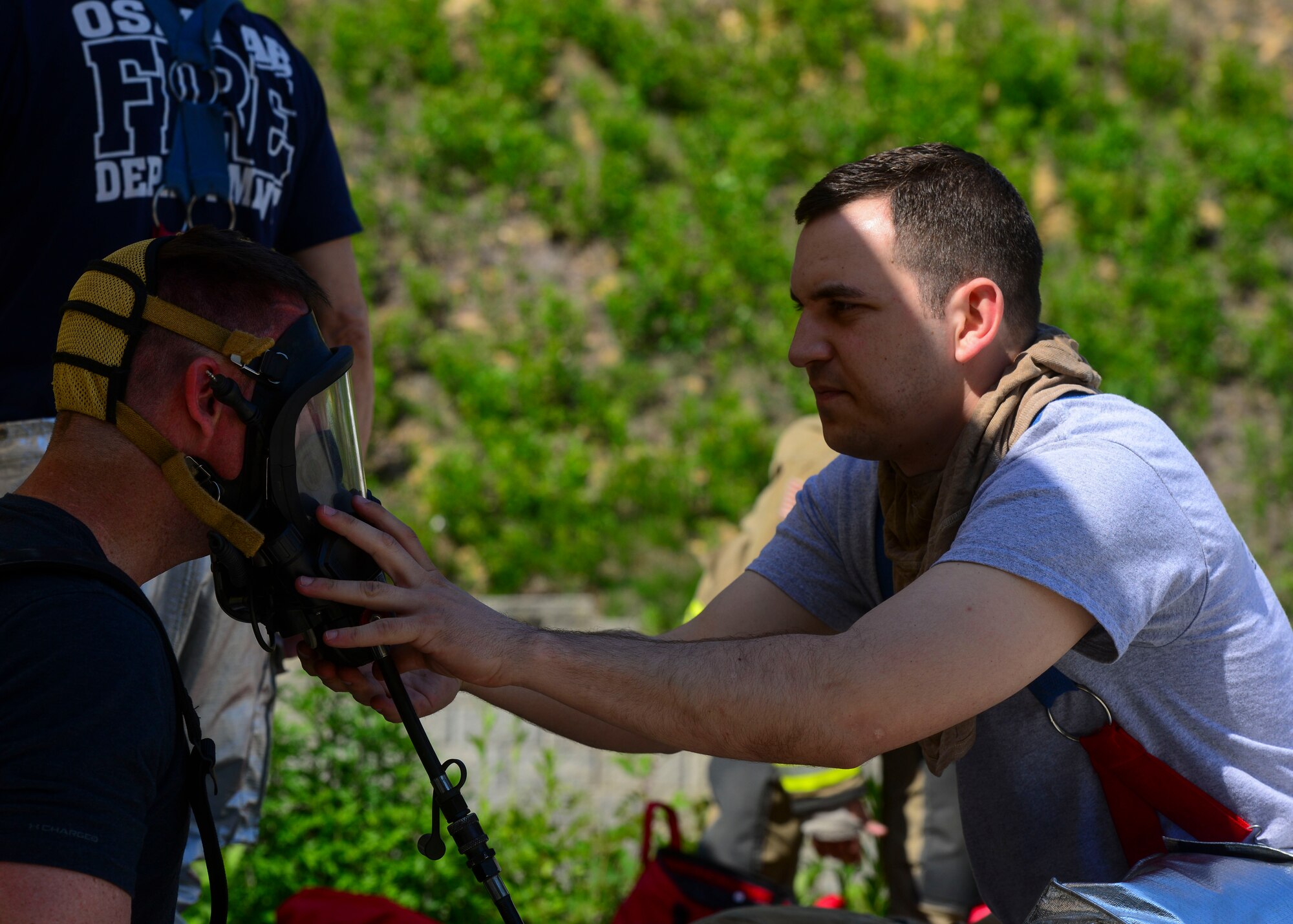 Staff Sgt. Michael White, 51st Civil Engineer Squadron fire and emergency services flight fire communications NCO in charge, helps adjust his wingman’s oxygen mask at the Kyonggi-do Fire Academy, Republic of Korea, May 18, 2016. The firefighters were preparing for live fire training which required them to wear all protective and heat resistant gear. (U.S. Air Force photo by Senior Airman Victor J. Caputo)