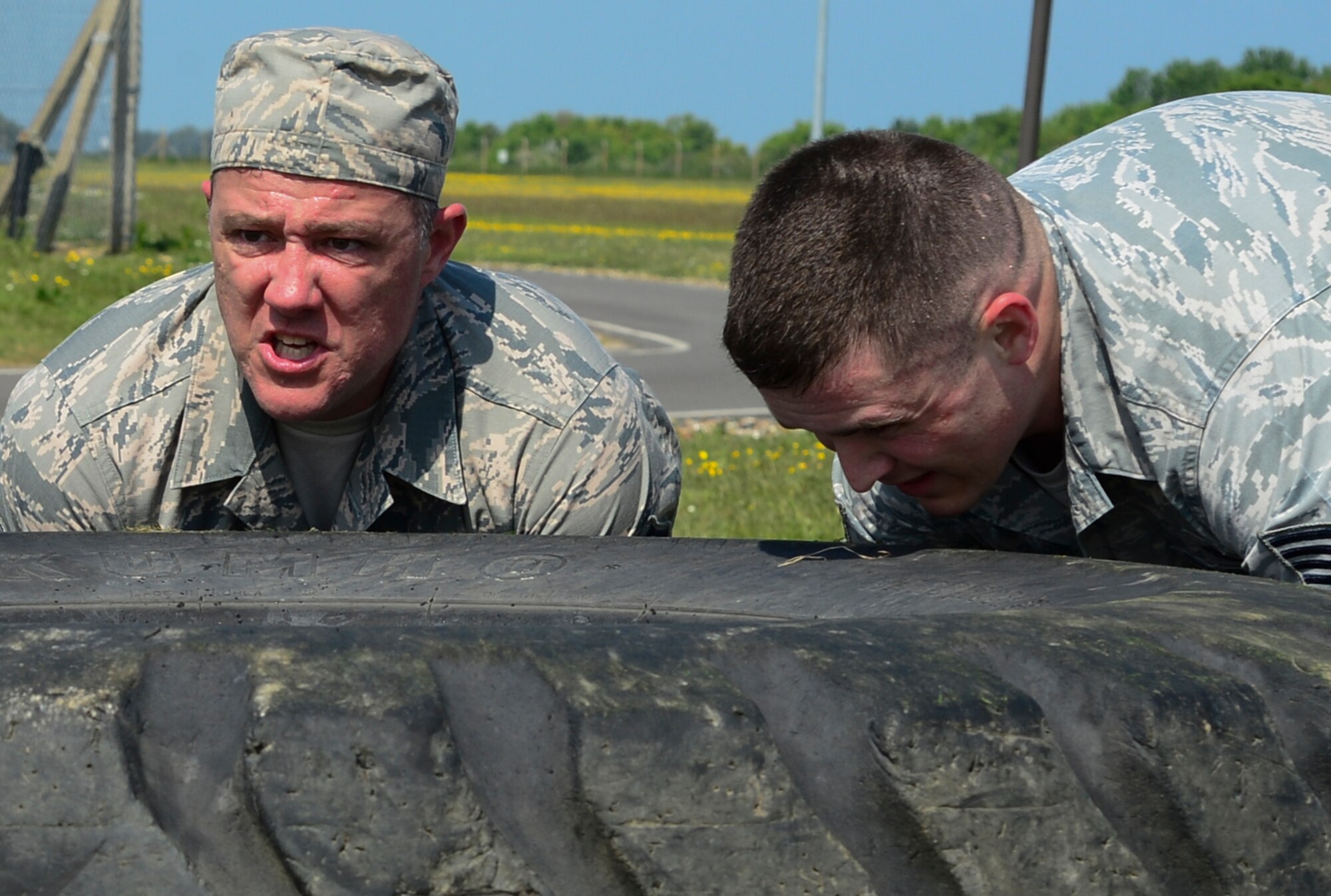 U.S. Air Force Master Sgt. Nick Beebe and Tech. Sgt. Kyle Billings, 48th Security Forces Squadron conduct a 400-pound tire flip during the Defender challenge for National Police Week at Royal Air Force Feltwell, England May 17. This year, both Lakenheath and Mildenhall Defenders conducted additional events throughout May 16-20. Which include a shooting competition, six mile ruck march, military working dog competition, community awareness display and closing ceremony. (U.S. Air Force photo/ Senior Airman Dawn Weber)