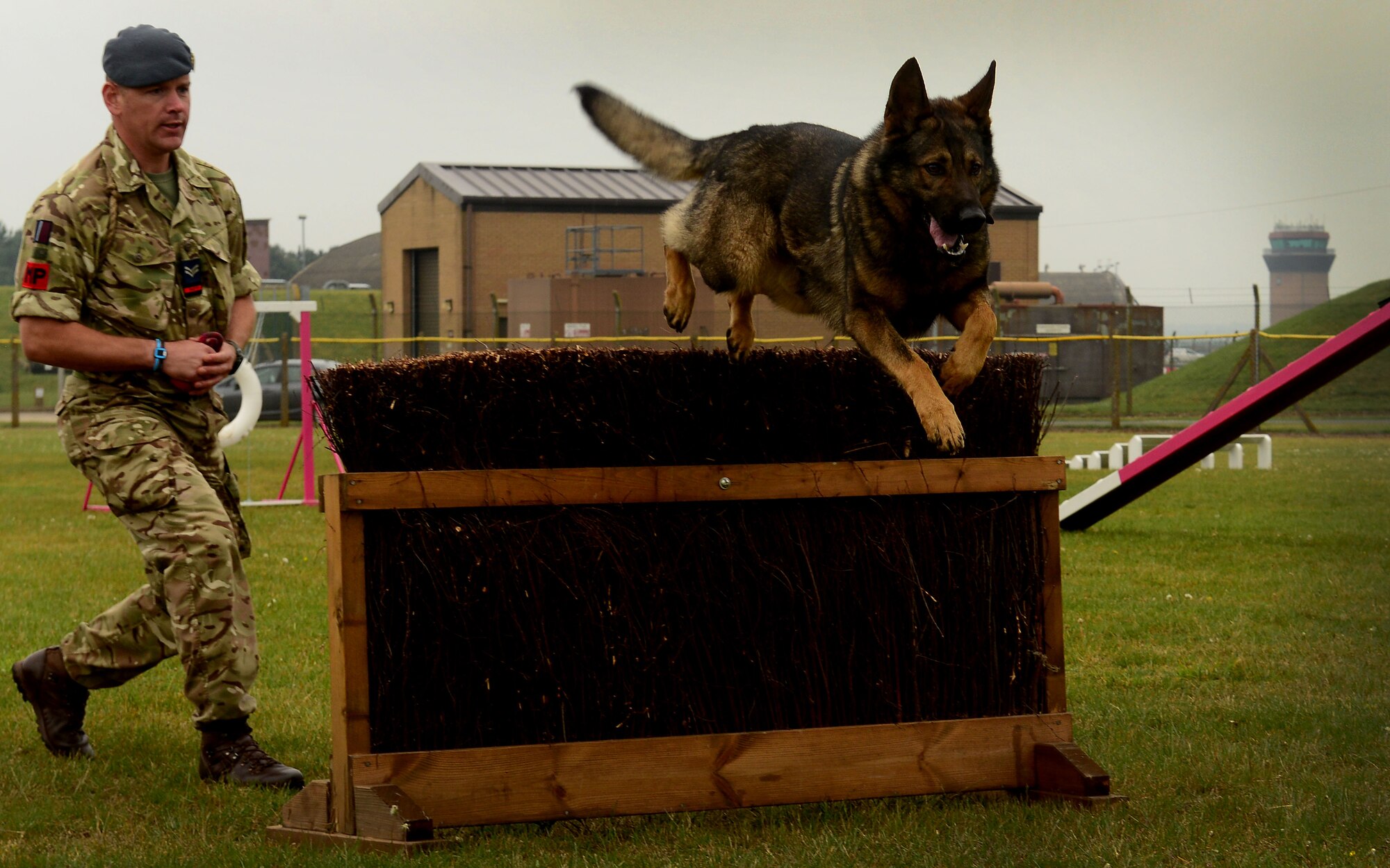 Royal Air Force Cpl. Ali Shannon, military working dog handler navigates his partner Tommy over an obstacle during a competition at RAF Lakenheath, England May 19. The event is part of U.S. National Police week, which recognizes the men, women and their canine companions who wear the badge. (U.S. Air Force photo/ Tech. Sgt. Matthew Plew)