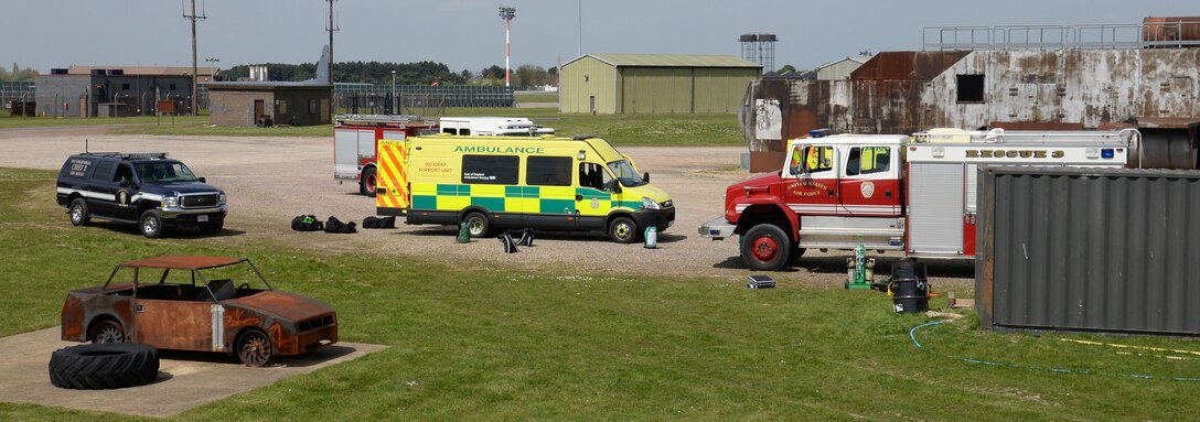 U.S. Air Force 100th Civil Engineer Squadron fire trucks stand ready with vehicles from the East of England Ambulance Service during a training exercise May 6, 2016, on RAF Mildenhall, England. Members of the 100th CES Fire Department teamed up with host nation emergency service responders to share skills and knowledge. (U.S. Air Force photo by Gina Randall/Released)