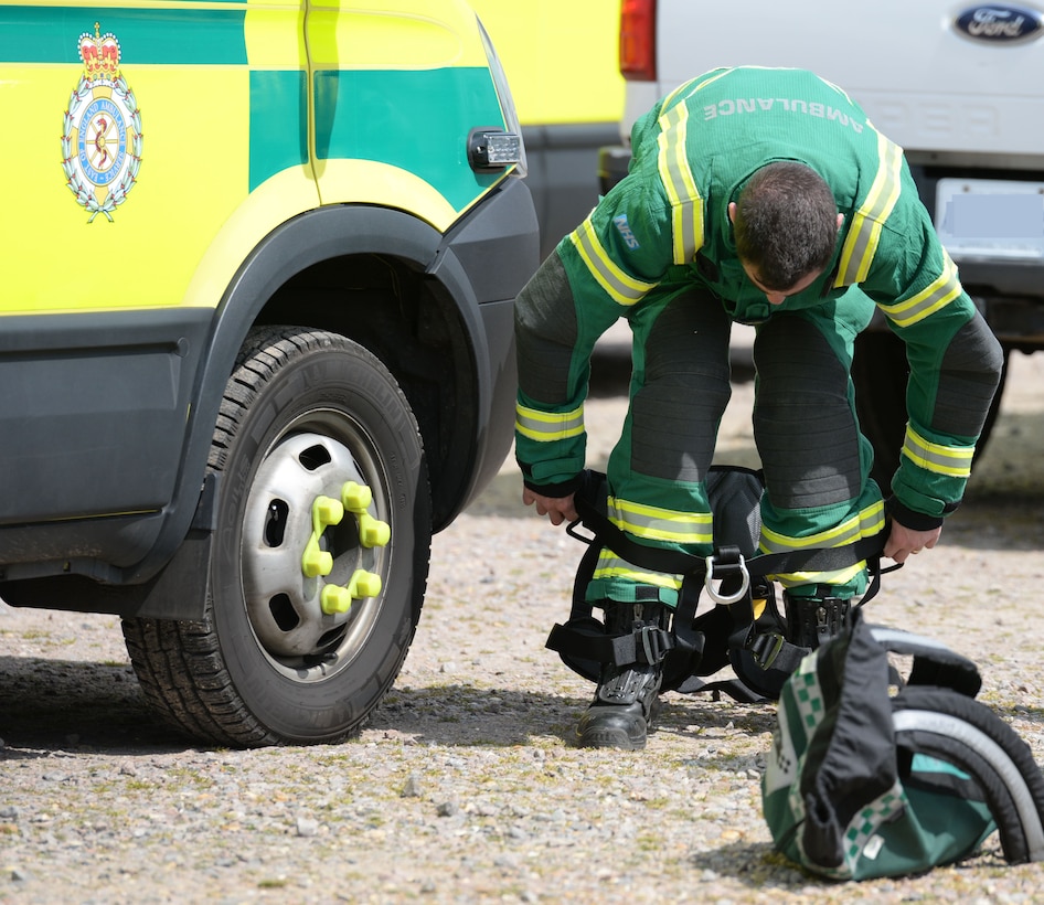 A paramedic from the East of England Ambulance Service Hazardous Area Response Team, dons his harness in preparation to respond to a confined space exercise May 6, 2016, on RAF Mildenhall, England. Members of the 100th Civil Engineer Squadron Fire Department teamed up with host nation emergency service responders to share skills and knowledge. (U.S. Air Force photo by Gina Randall/Released)