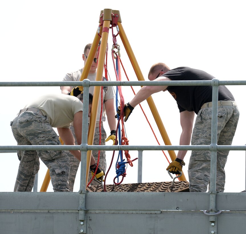 U.S. Air Force Airman 1st Class Camden Ramsey, left, U.S. Air Force Senior Airman Conor Delaney, center, and U.S. Air Force Tech. Sgt. Archibald Pritchett, right, all 100th Civil Engineer Squadron firefighters, set up a tripod assembly for confined space rescue training May 6, 2016, on RAF Mildenhall, England. The tripod is used to lower rescue personnel into confined spaces. (U.S. Air Force photo by Gina Randall/Released) 