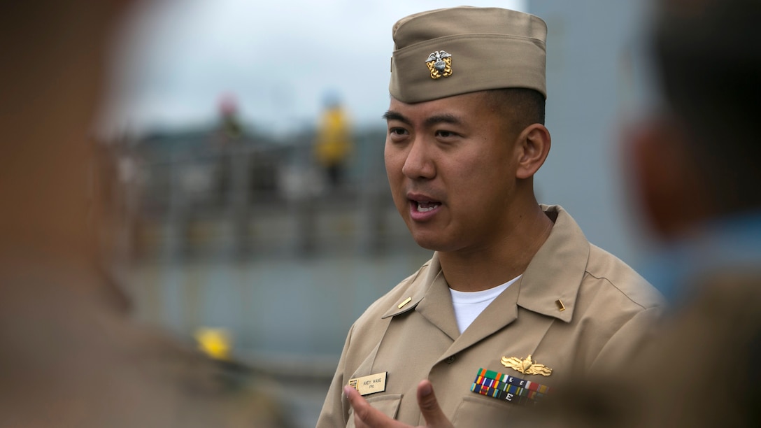 Navy Ensign Andy Wang explains naval traditions, rules and regulations to Marines and Sailors of Task Force Koa Moana before they board the USNS Sacagawea for a series of bilateral, multinational exercises at Tengan Pier, Okinawa, Japan, May 17, 2016. The series of exercises provide basic military training and the opportunity to exchange engineering and infantry tactics between participating nations to increase interoperability and to preserve peace in the Asia-Pacific region. Wang, from Canton, Mich., is the liaison officer for USNS Sacagawea. His job is to provide a link between the ship’s staff and the service members aboard.