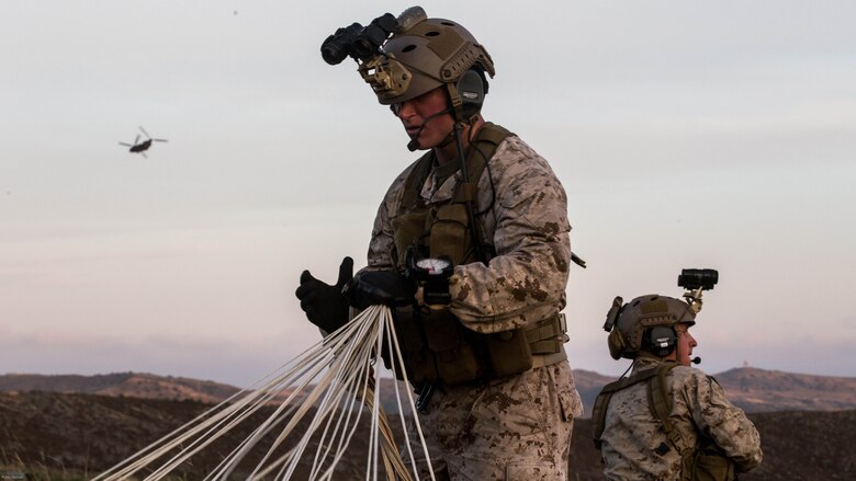 A reconnaissance man with the Maritime Raid Force, 11th Marine Expeditionary Unit, secures his parachute after an air insert into a reconnaissance and surveillance mission at a MEU field exercise aboard Marine Corps Base Camp Pendleton, Calif., May 12, 2016. The Maritime Raid Force provides a unique capability to the MEU commander and can respond to a number of mission requirements the MEU may respond to such as visit, board, search and seizure, reconnaissance and surveillance, and direct action raids. 