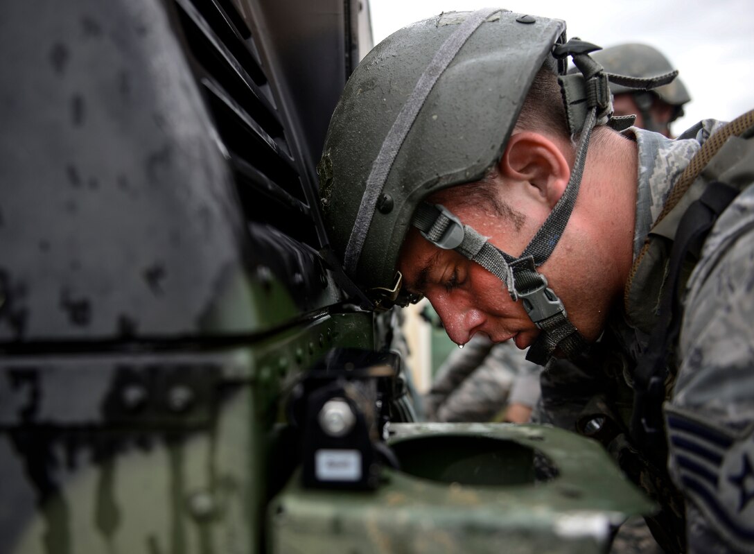 Staff Sgt. Joshua Ferguson, 31st Security Forces Squadron training instructor, takes a break while he helps push a Humvee during the Police Week Fire Team Challenge, May 19, 2016, at Aviano Air Base, Italy. The Humvee push was one of 12 stations testing the participant’s mental and physical strength. (U.S. Air Force photo by Senior Airman Krystal Ardrey/Released)