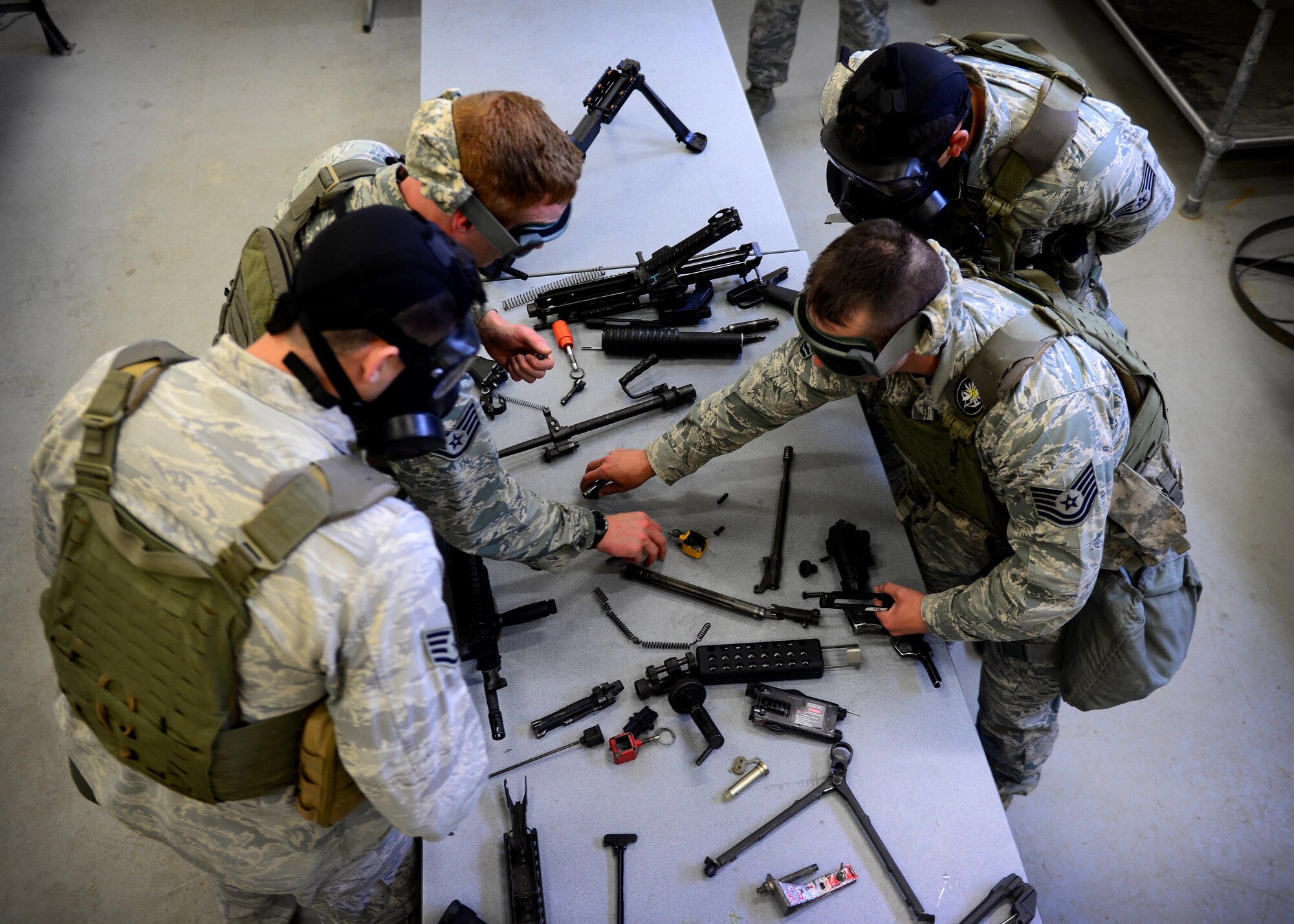 Airmen assigned to the 31st Security Forces Squadron, assemble weapons blindfolded during the Police Week Fire Team Challenge, May 19, 2016, at Aviano Air Base, Italy. The weapons assembly was one of 12 stations testing the participants’ mental and physical strength. (U.S. Air Force photo by Senior Airman Areca T. Bell/Released)