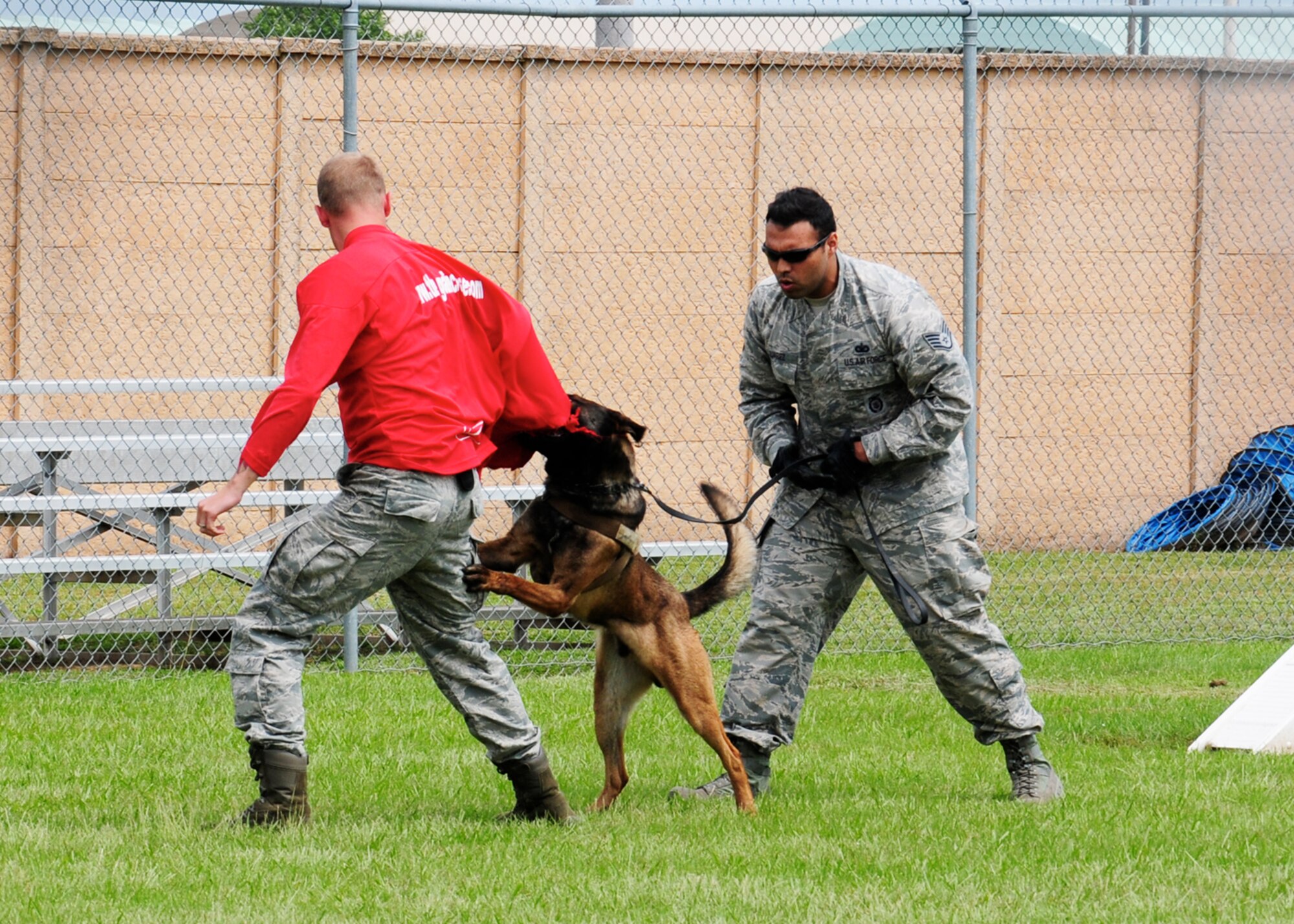 Military Working Dog Ooleg takes a bite out of Senior Airman Kyle Jacob, 14th Security Forces Squadron, while Staff Sgt. Jimmy Juarez, 14th Security Forces Squadron, issues commands during a MWD demonstration May 17 for the 2016 Police Week Demonstration Day event held on Columbus Air Force Base, Mississippi. Although Police Week is essentially to honor law enforcement officers, it is also made to be fun and entertaining while also educational for those attending.  Attendees had not only the opportunity to see the military dogs in action, but the chance to learn about the care they receive. (U.S. Air Force photo/Elizabeth Owens)