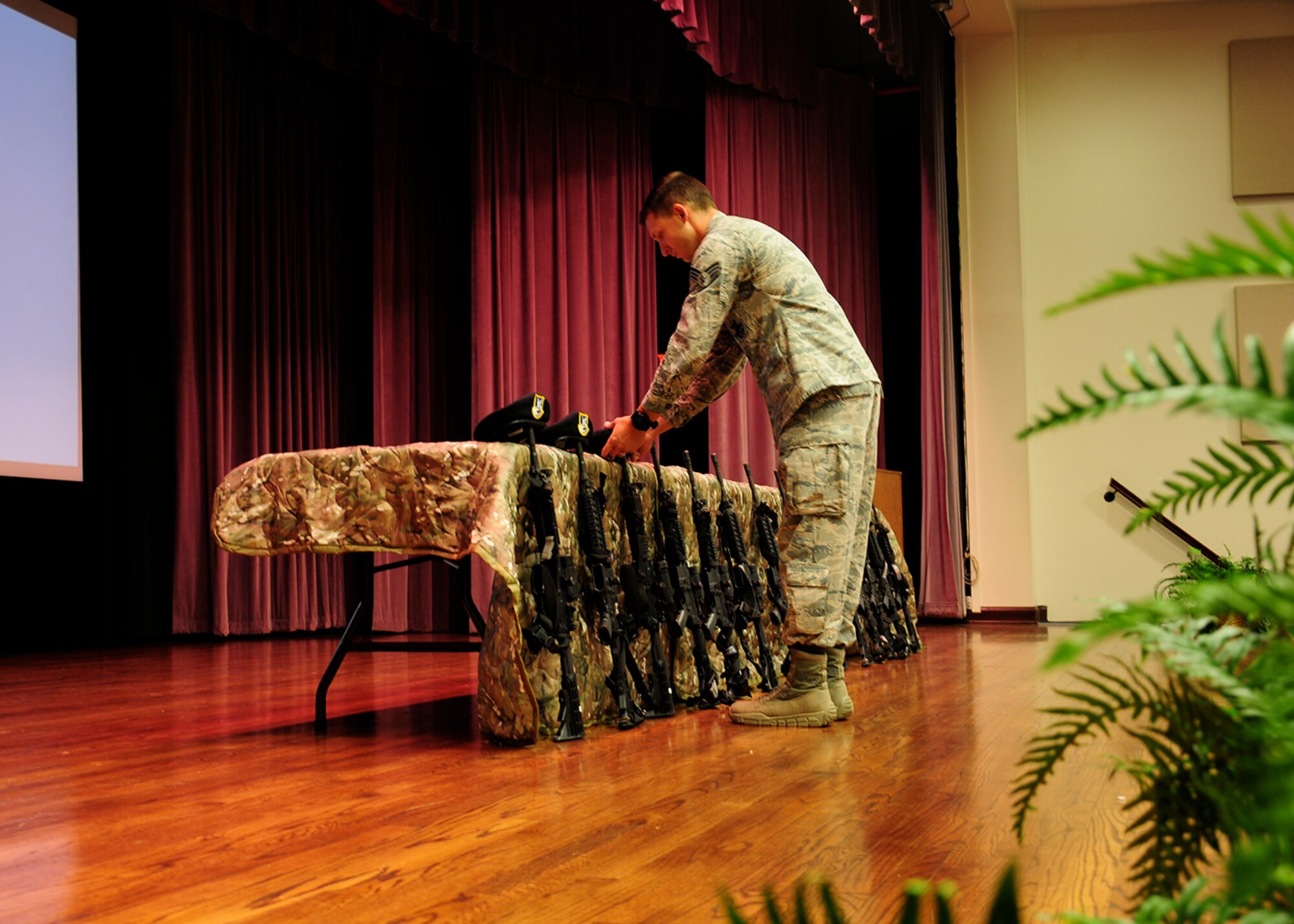 Senior Airman Evan Narred, 14th Security Forces Squadron, places a beret on a memorial during the Fallen Defenders Presentation May 18 in the Kaye Auditorium on Columbus Air Force Base, Mississippi. Attendees learned about the sacrifices made by security forces Airmen. (U.S. Air Force photo/Elizabeth Owens)
