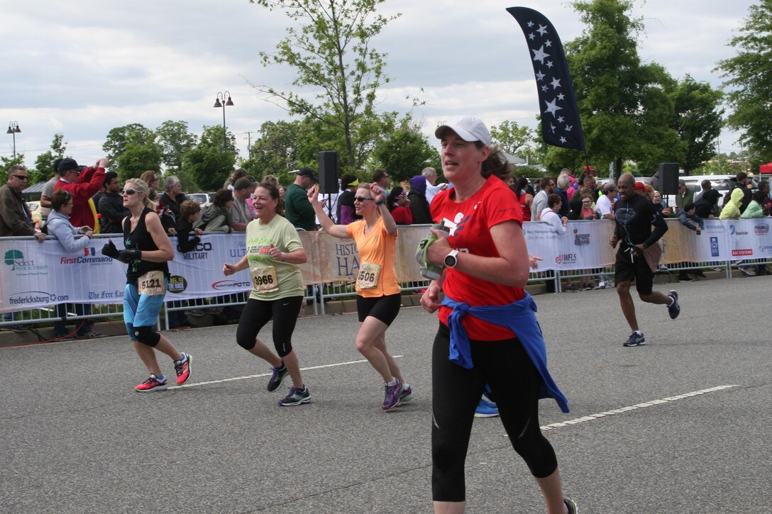 Marianne Paoli, 56, of Haddonfield, N.J., and Sue Burns, 48, of Moorestown, N.J., celebrate approaching the finish line of the ninth annual Marine Corps Historic Half.