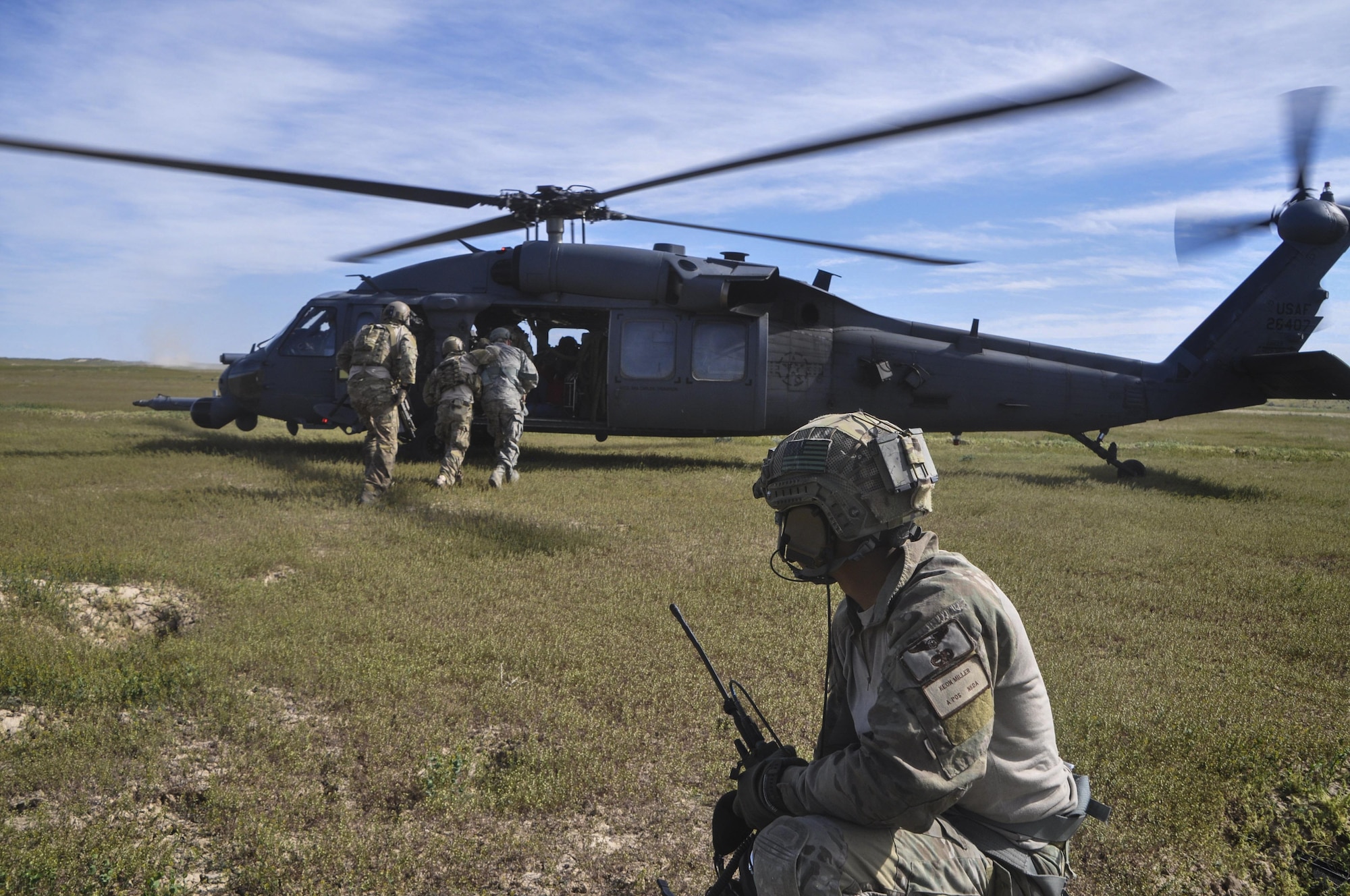 Staff Sgt. Keon Miller, 66th Rescue Squadron special mission aviator, watches pararescue personnel recover a simulated downed service member during the 34th Weapons Squadron’s Terminal Employment phase at the Orchard Range Training Complex in Boise, Idaho, on April 20. Miller was one of two students participating in a concept course on advanced tactics for HH-60G Pave Hawk SMAs. 