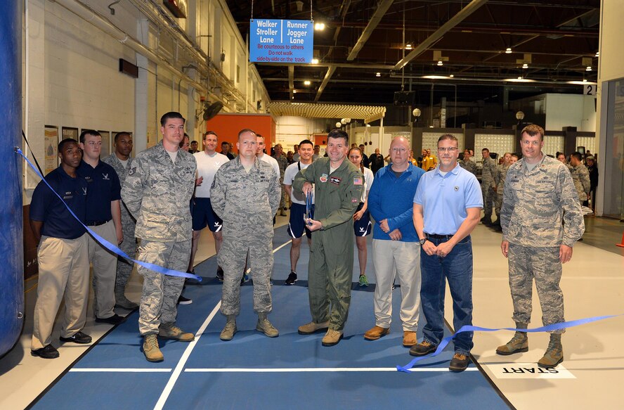 U.S. Air Force Col. Marty Reynolds, commander of the 55th Wing, ceremoniously cuts a blue ribbon to officially open the new running track at the Offutt Field House May 16, Offutt Air Force Base, Neb.  A combination of synthetic and natural rubber compounds make up the spike resistant multisport running surface.  The nearly half-mile-long track will last an estimated ten years.  (U.S. Air Force photo by Josh Plueger/Released)