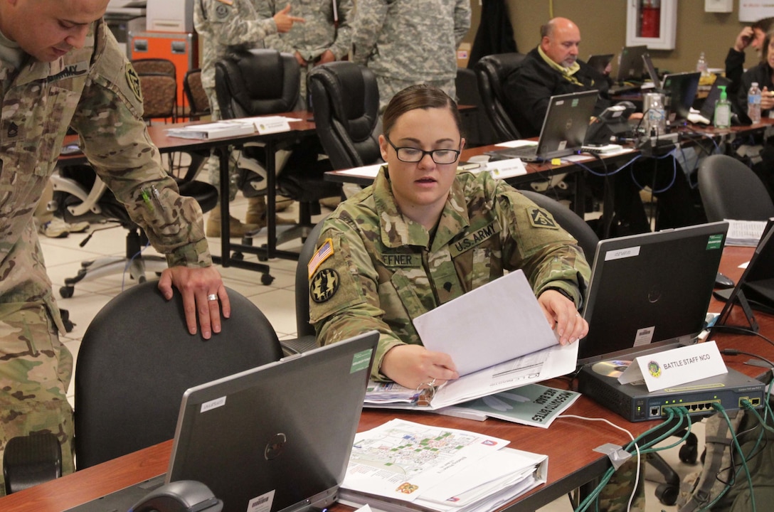 Army Spc. Robin Hefner, a human resource specialist assigned to U.S. Army North, goes over Vibrant Response 16 battle plans with another Tactical Operations Center soldier at Camp Atterbury, Indiana, May 3, 2016. VR 16 is led by ARNORTH and brings military, federal, and state agencies together to train to respond to a national emergency. Army photo by Sgt. William Washburn