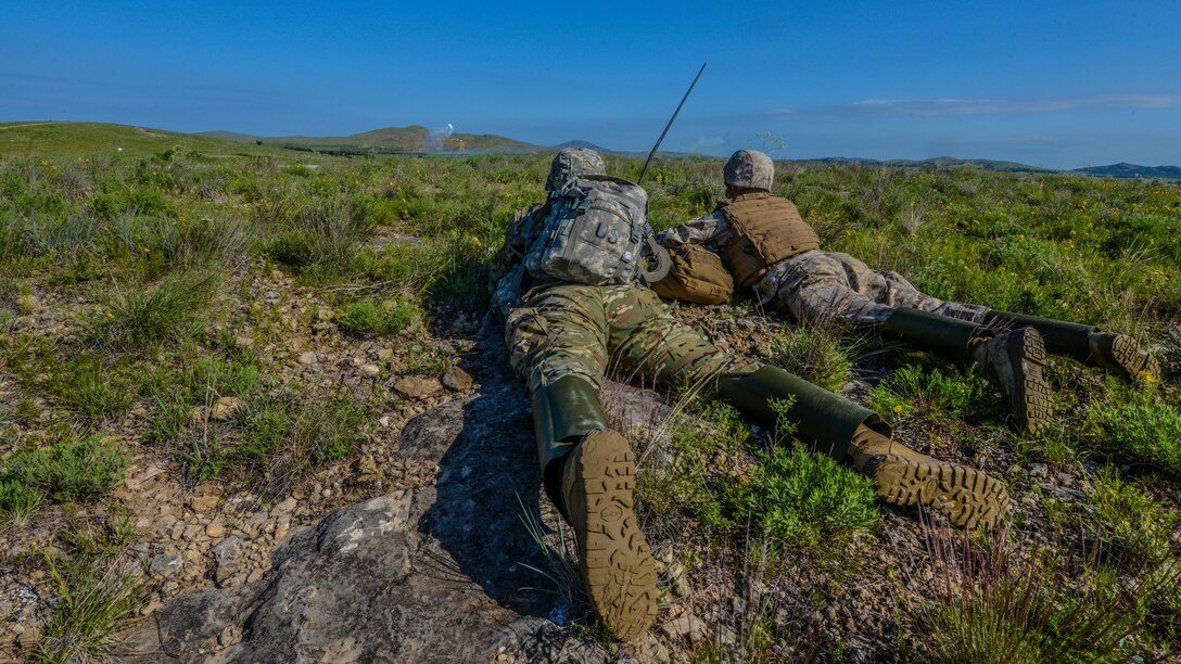 Second Lt. William Ostermeyer, left, and 2nd Lt. Daniel Lowery call for fire on an enemy position at the Field Artillery Basic Officers Leadership Course at Fort Sill, Oklahoma, May 12, 2016. Marines and soldiers train cohesively through the five-month course. 