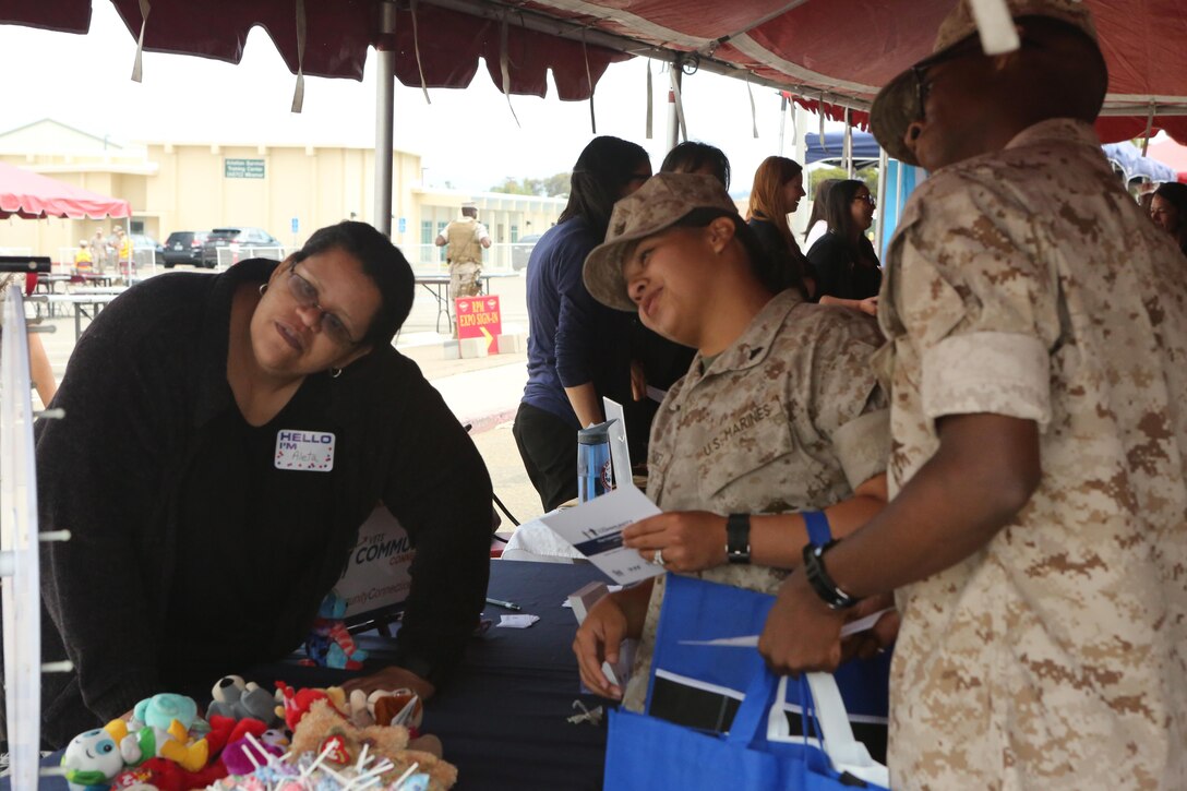 Service members play a game at a booth during the Relationships, Marriage and Parenting Exposition aboard Marine Corps Air Station Miramar, Calif., May 11. The expo provided Marines, Sailors and families of 3rd Marine Aircraft Wing with resources to strengthen relationships and families.  (U.S. Marine Corps photo by Pfc. Liah Kitchen/Released)