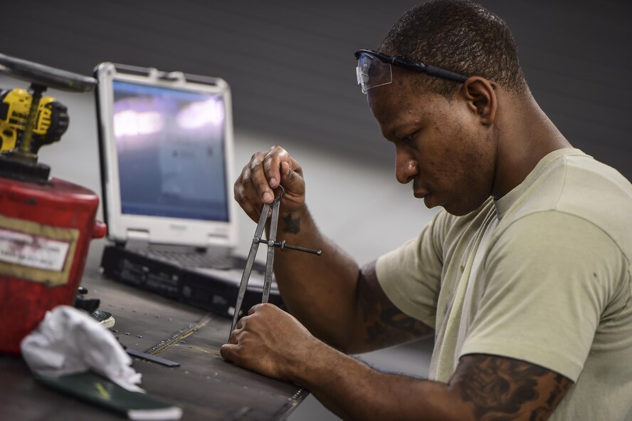 Staff Sgt. Sean Ciccel, an aircraft structural maintenance craftsman with the 1st Special Operations Maintenance Squadron, uses a compass to measure a C-130 wing flap at Hurlburt Field, Fla., May 17, 2016. Airmen with the 1st SOMXS aircraft structural maintenance shop save the Air Force more than $100,000 a year by replacing damaged parts with items fabricated in their shop. (U.S. Air Force photo by Staff Sgt. Christopher Callaway)